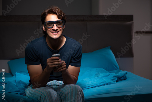 Man watching tv at night in bed