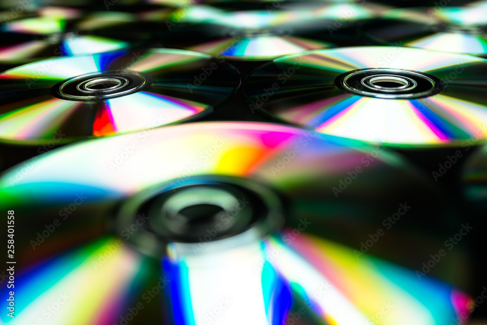 CDs / DVDs lying on a black background with reflections of light. CDs / DVDs lying on a black background with reflections of light.