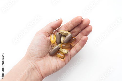 Treatment and pharmacy concept. Colorful pills in the hand on white background
