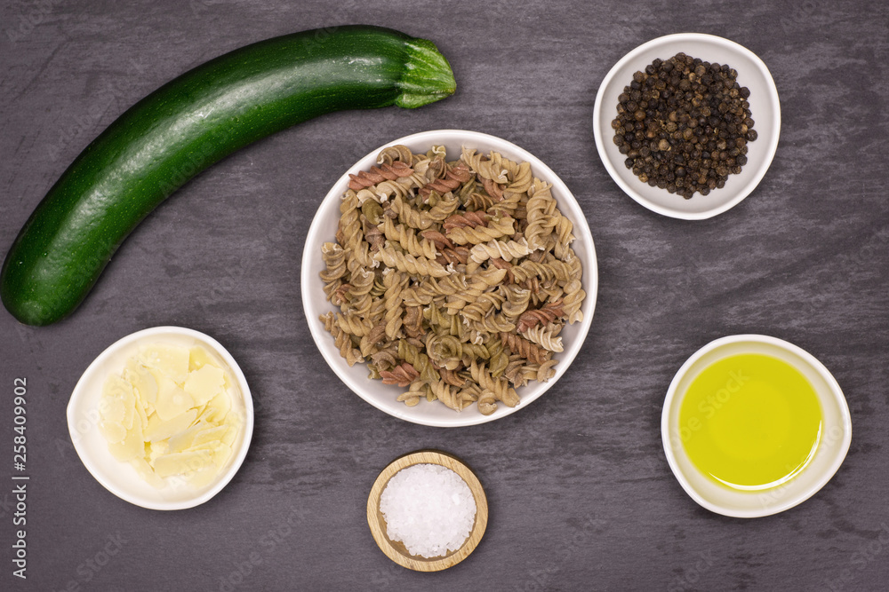 Set of ingredients. recipe step by step fusilli pasta with zucchini flatlay on grey stone Set of ingredients. recipe step by step fusilli pasta with zucchini flatlay on grey stone