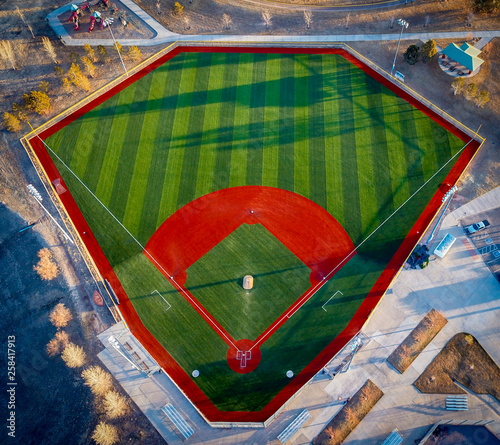 Aerial drone wide angle view of a green baseball field diamond in the morning sunlight ready for play.