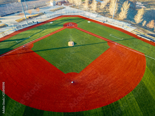 Aerial drone wide angle view of a green baseball field diamond in the morning sunlight ready for play.