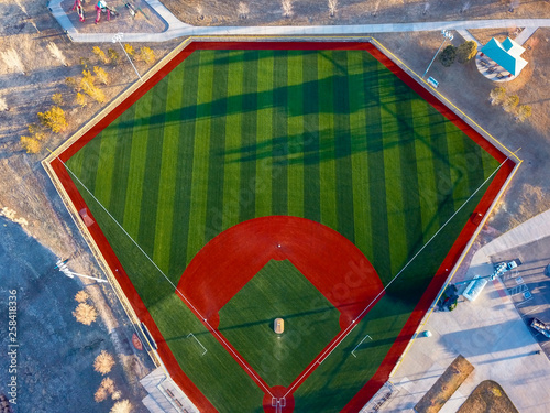 Aerial drone wide angle view of a green baseball field diamond in the morning sunlight ready for play.