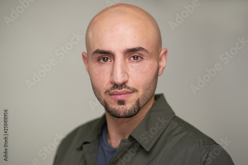 Portrait of bald man with green shirt in studio
