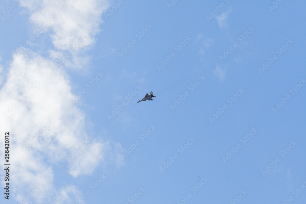 Military fighter in the blue sky with white clouds