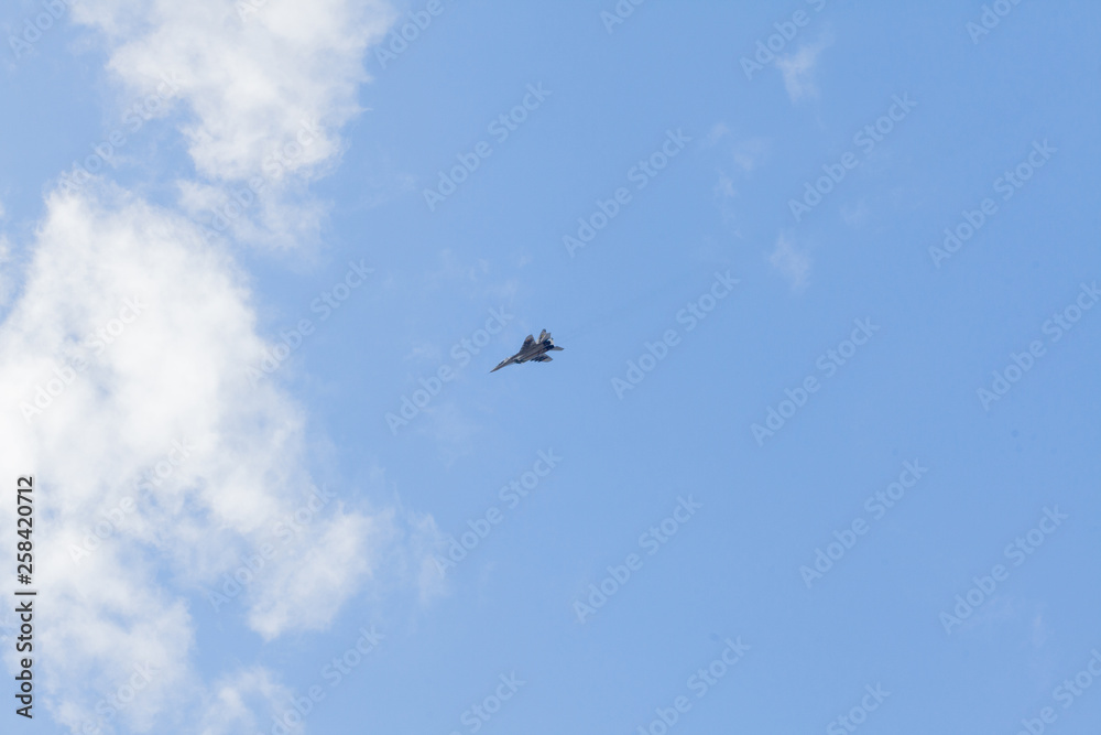 Military fighter in the blue sky with white clouds Military fighter in the blue sky with white clouds
