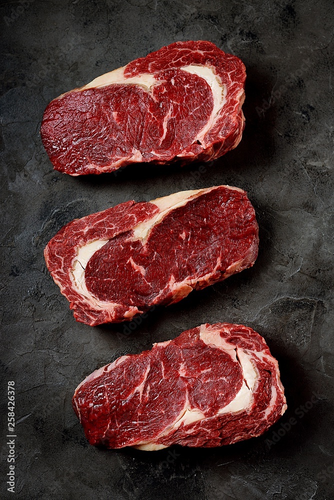 Raw fresh beef steak rib eye on old wooden background. Rustik Style. Top view.