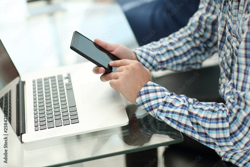 Fototapeta premium close up.business man with a smartphone sitting at his Desk
