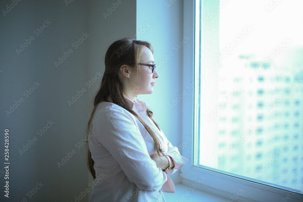 Executive business woman looking out the office window Executive business woman looking out the office window