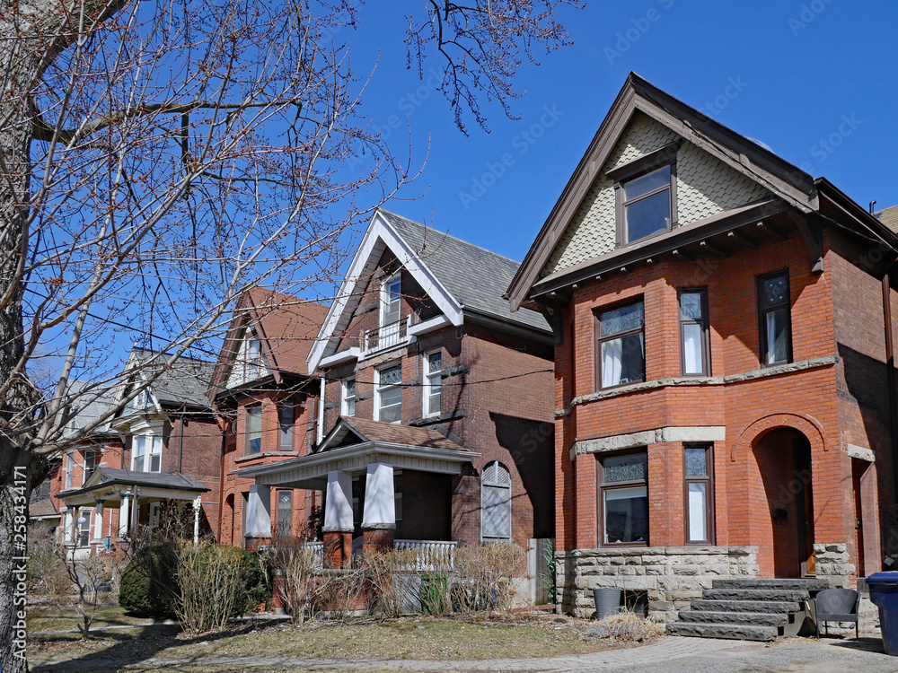 Row of large old Victorian style detached brick houses with gables Row of large old Victorian style detached brick houses with gables