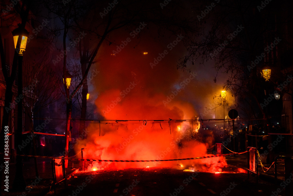 Naklejka premium Colorful mascleta full of firecrackers and fireworks with lots of smoke and sparks.