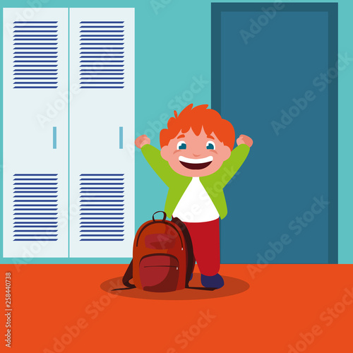 little schoolboy with schoolbag in school corridor