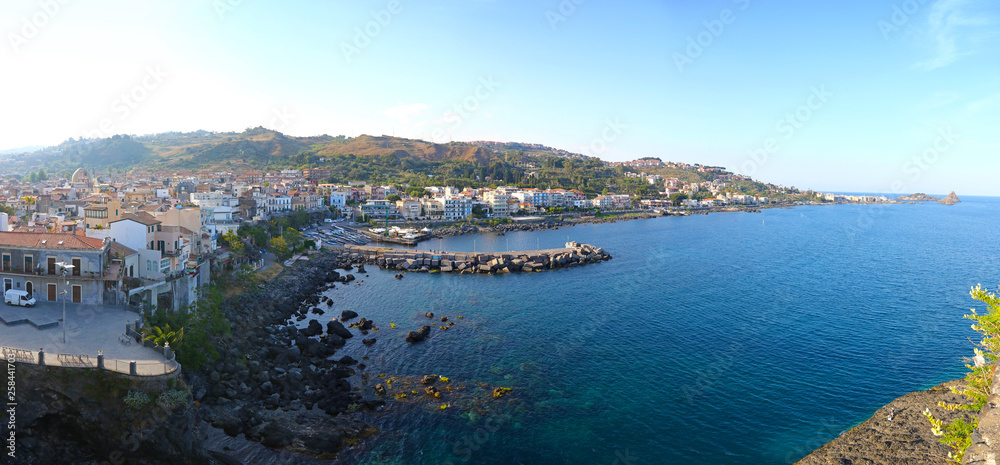Rocky mediterranean coastline near the town of Aci Castello, Sicily, Italy. View from Norman Castle. Cyclops Islands on the background