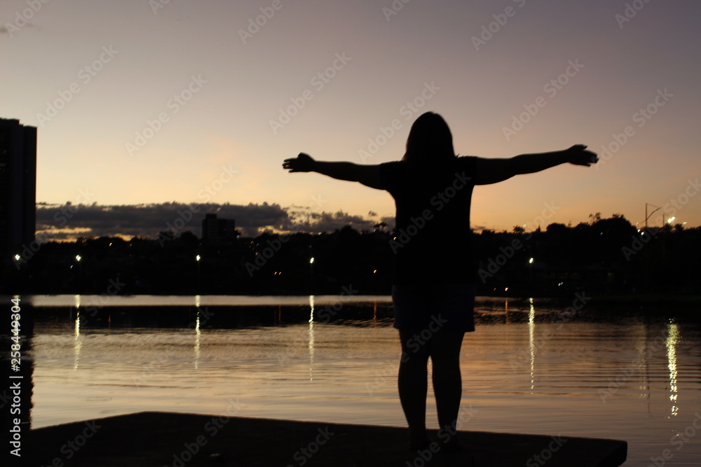 Fototapeta premium silhouette of young woman doing yoga at sunset