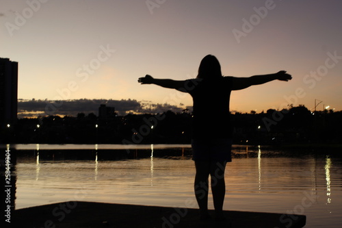 silhouette of young woman doing yoga at sunset