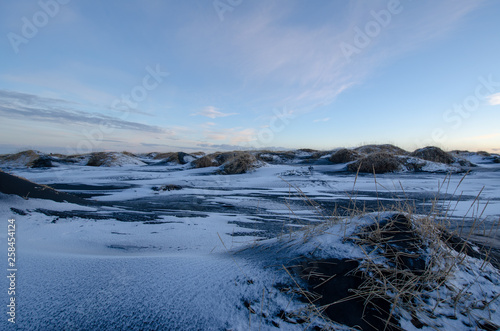 Black sand dunes covered in snow