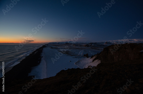Sunset over Iceland cliffs and ocean during winter