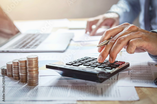 businessman working on desk with using calculator for calculate finance and accounting in office