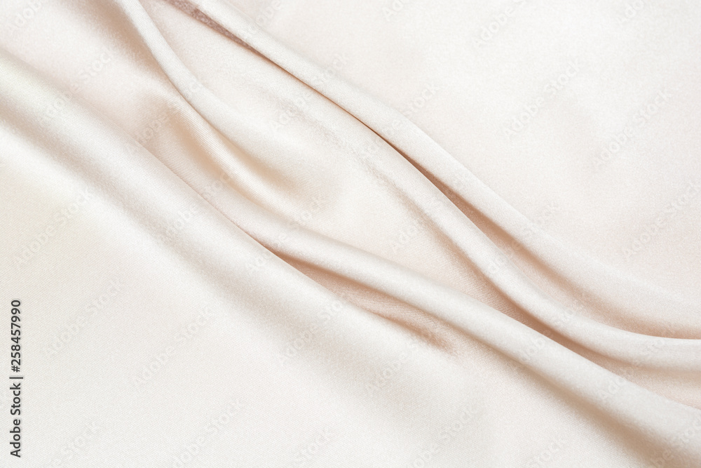 Fototapeta premium The texture of the satin fabric of beige color for the background