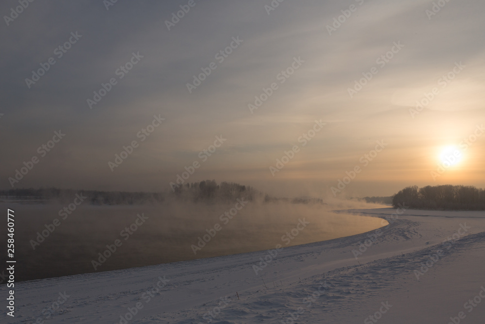 winter frosty sunset on the river in Siberia in winter