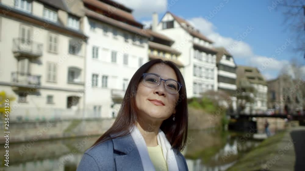 Portrait of a Japanese woman standing in the middle of a street in Europe with soft natural light Portrait of a Japanese woman standing in the middle of a street in Europe with soft natural light