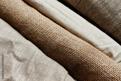Fotografie Natural fabrics from organic colors of flax and cotton in rolls, homespun textile handmade
