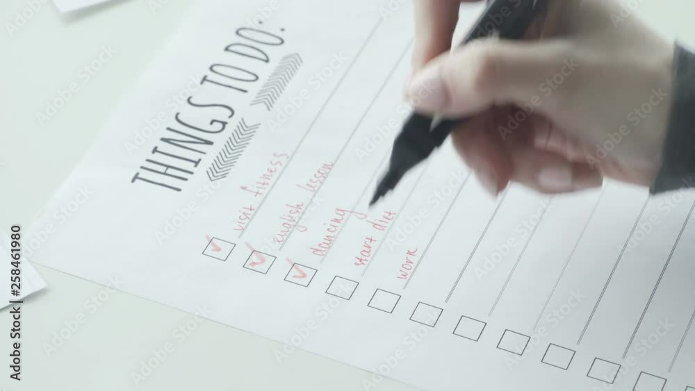 Female hand putting mark on check boxes of to do list Female hand putting mark on check boxes of to do list