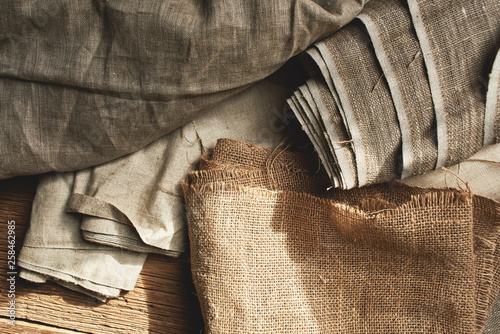 Natural fabrics from organic colors of flax and cotton in rolls, homespun textile handmade. Burlap and canvas for eco, rustic, boho, hygge decor