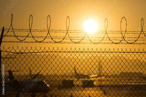 security fence around international airport at sunrise