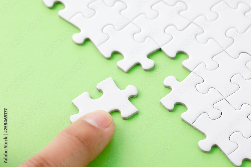 Obraz premium ジグソーパズル White jigsaw puzzle on green background