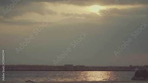 Thessaloniki / Greece 28 march 2019 :girls are  seating in the road by the sea they enjoy the good weather and the sunset