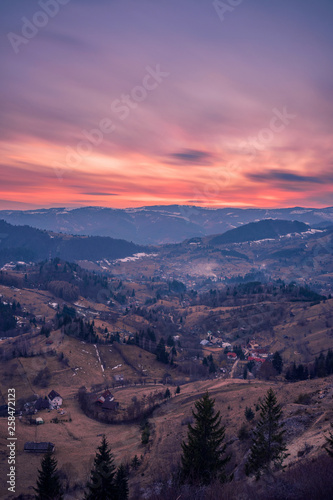 Small village placed in a valley between mountains seen from above at sunset shot in Romania with a long exposure © ionutpetrea