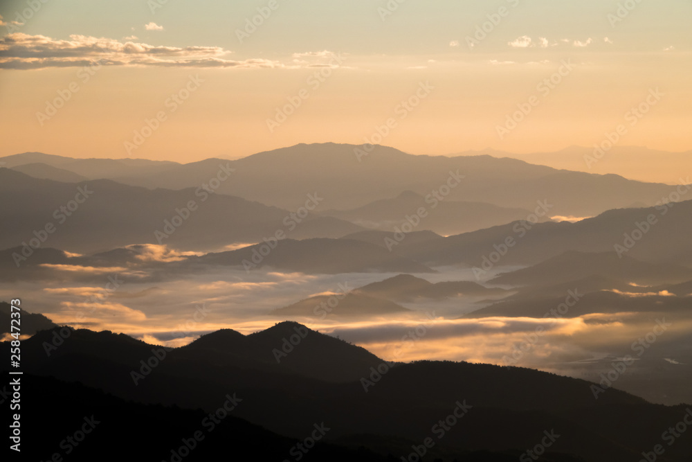 Landscape view black mountains and forest silhouette under skyscape sunlight and clouds with mist and fog. Northern in Thailand.