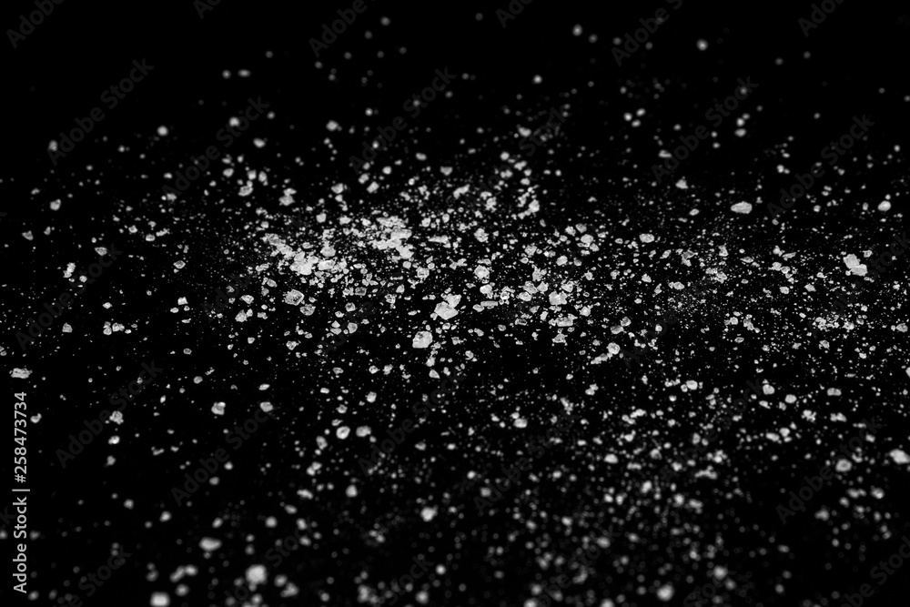 white crystalline powder on a black background. sugar dust 