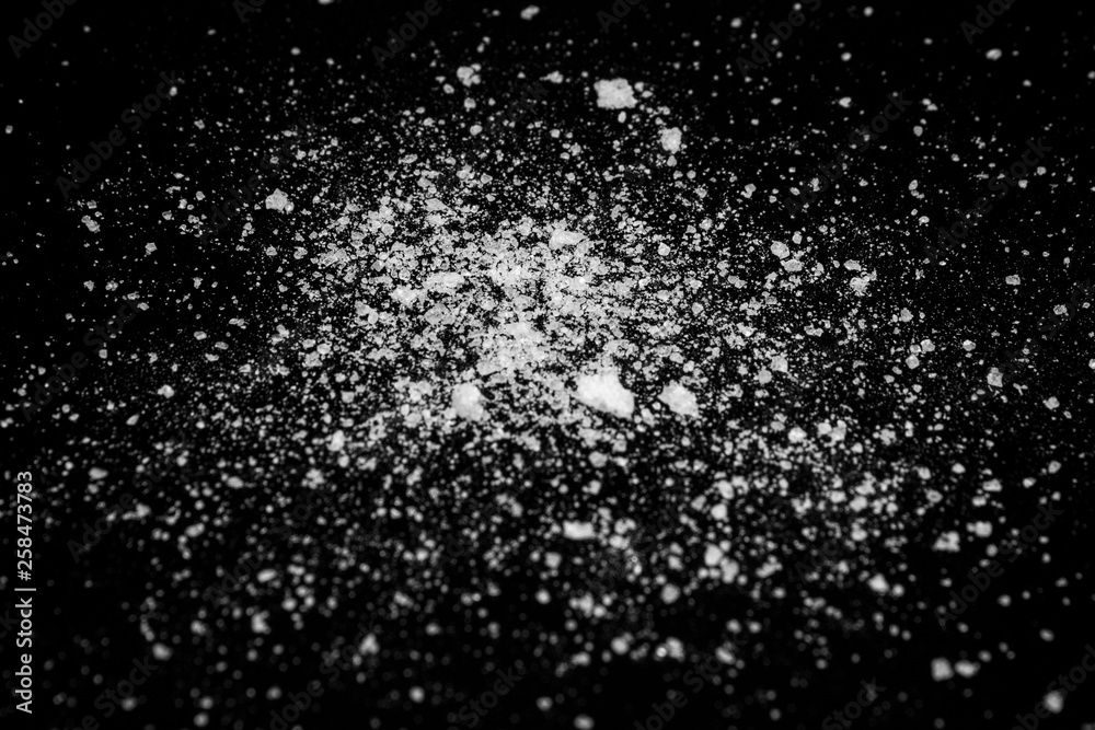 white crystalline powder on a black background. sugar dust 