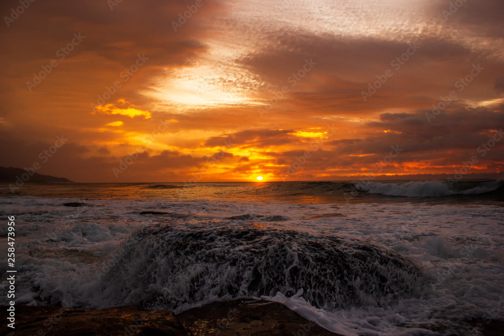 waves crushing a rock during sunrise. Sea sunrise at the great Ocean Road, Victoria, Australia