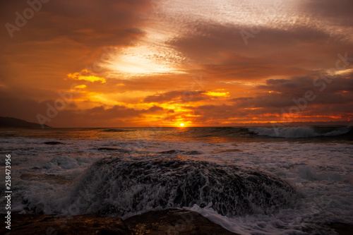 waves crushing a rock during sunrise. Sea sunrise at the great Ocean Road  Victoria  Australia