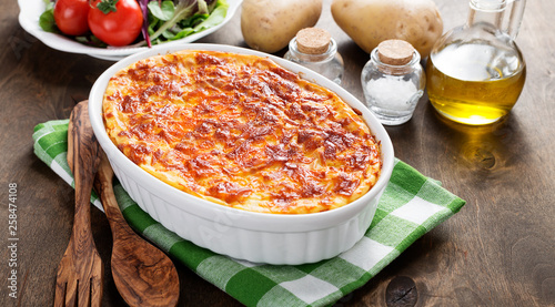 Potato casserole with meat on  wooden table. photo