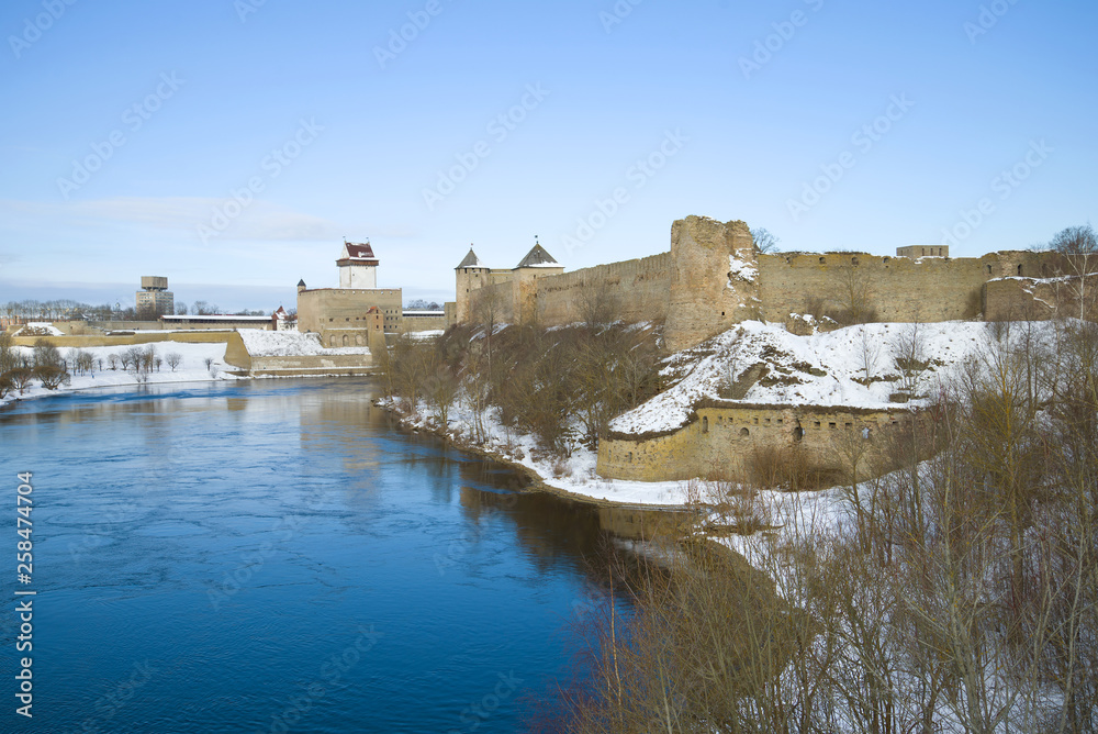 View of the Ivangorods Fortress and Herman Castle on the Narva River border in March afternoon. Border of Russia and Estonia