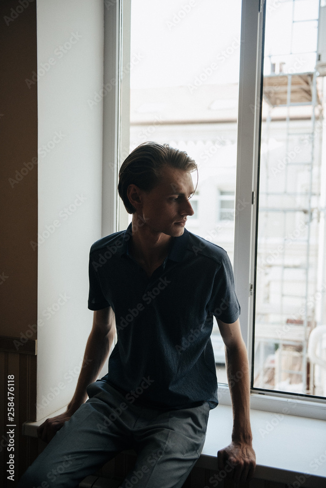A man in a blue polo poses for menswear advertising. Shooting for men's clothing store A man in a blue polo poses for menswear advertising. Shooting for men's clothing store