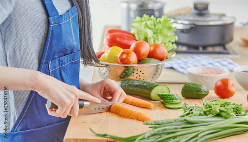 A young woman prepares food in the kitchen. Healthy food - vege