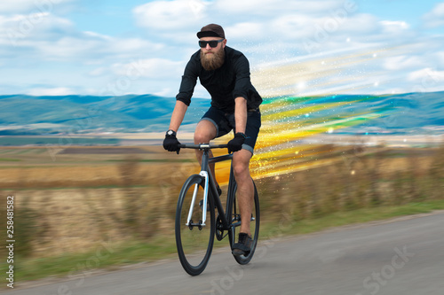 Young riding bicycle in fabulous nature with high speed