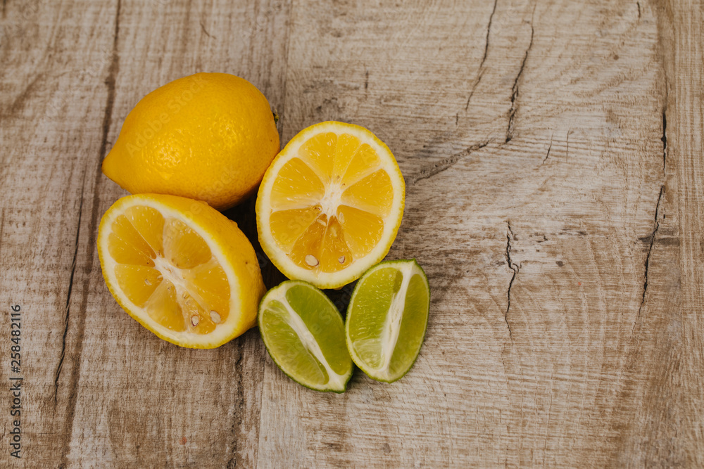 half of lime and lemon on wood background half of lime and lemon on wood background