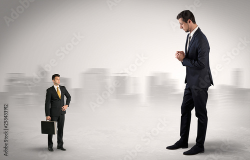 Giant businessman being afraid of small serious executor with suitcase   © ra2 studio