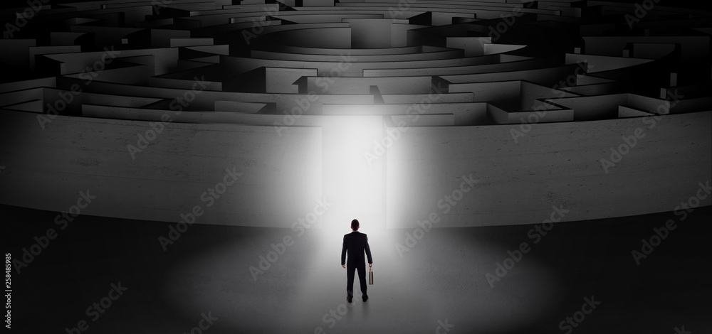 Businessman getting ready to enter a concentric labyrinth with lighted entrance concept
Businessman getting ready to enter a concentric labyrinth with lighted entrance concept