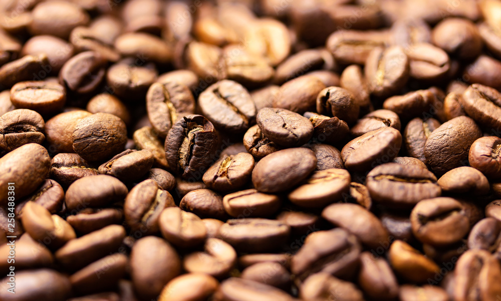 Pile of coffee beans texture, close up, dark background, shallow depth of field