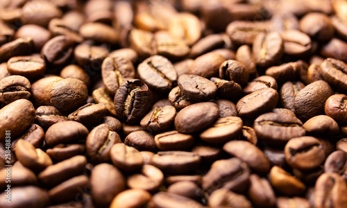 Pile of coffee beans texture  close up  dark background  shallow depth of field