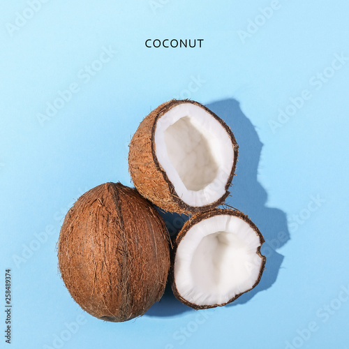 Coconuts on a blue background, top view. Tropical summer concept, copy space.