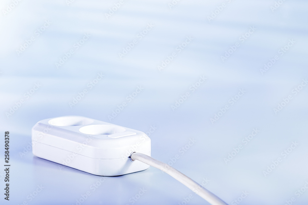Electric socket for connecting electrical equipment on light blue surface with copy space. Concept supply or consumption energy. Electric socket for connecting electrical equipment on light blue surface with copy space. Concept supply or consumption energy.