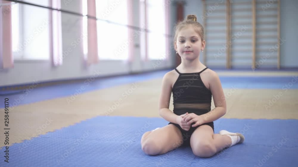 Girl performing rhythmic gymnastics exercises with a ball. Professional sport concept Girl performing rhythmic gymnastics exercises with a ball. Professional sport concept